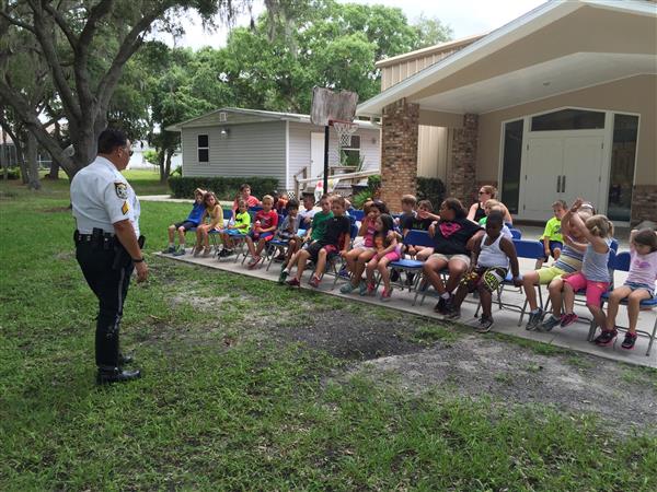 sheriff speaks to class sitting in chairs outside